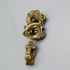 a gold dragon brooch on a white background