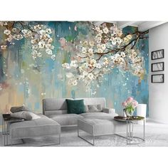 a living room with a couch, table and wall mural on the wall that has flowers painted on it