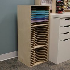 a wooden cabinet with many different colored fabrics on it's shelves next to a white dresser