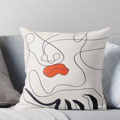 a white and orange pillow sitting on top of a couch