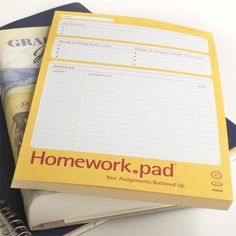 two notebooks sitting next to each other on top of a white table with pens and scissors