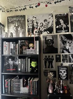 a book shelf filled with lots of books next to a wall covered in halloween pictures