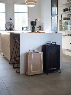 two bags sitting next to each other on the floor in front of a counter top