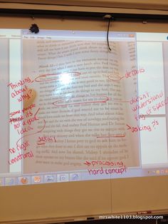 an open book with writing on it in front of a projector screen that is projected onto the wall