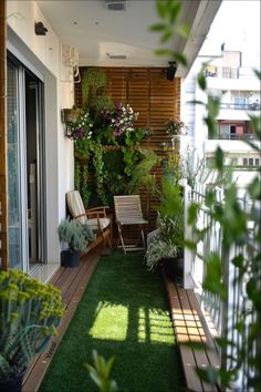 an apartment balcony with artificial grass and potted plants