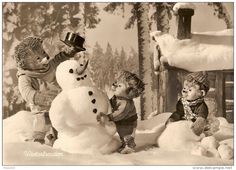 three children building a snowman in the snow