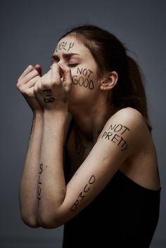 a woman with her hands on her face and words written all over her body that spell out the word, it's not good