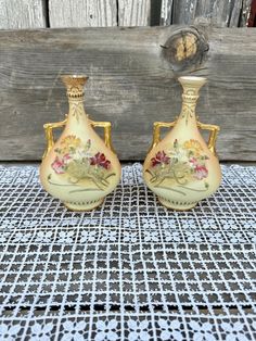 two small vases sitting on top of a table