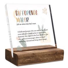 a clear acrylic sign on a wooden stand that says, diffrentce maker