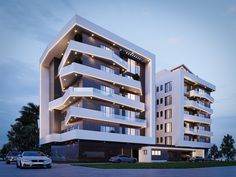 a large white building with many balconies on the top floor and two cars parked in front of it