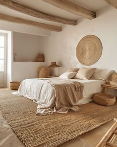 a bed sitting in a bedroom next to a wooden table and chair on top of a rug