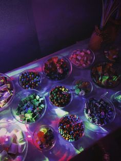 a table topped with lots of candy and candies on top of glass bowls filled with candy