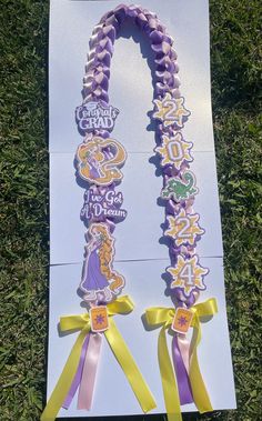 a purple and yellow ribbon is on top of a white paper with an image of princess