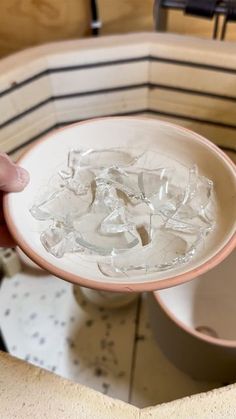 a person holding a bowl with ice in it