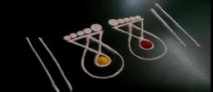 four matches are lined up in the shape of three drop - shaped objects, one yellow and one red