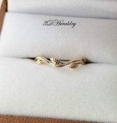 a gold ring with leaves on it in a box