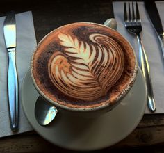 a cappuccino on a plate with silverware