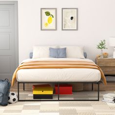 a bedroom with a bed, nightstands and two pictures on the wall above it