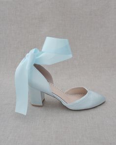 a pair of white shoes with a light blue bow