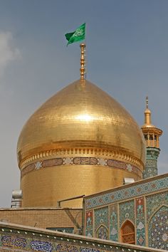 a large gold dome on top of a building with a green flag flying above it