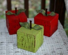 three red and green apples sitting on top of a table