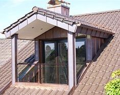 the roof of a house with a window and an open skylight on it's side