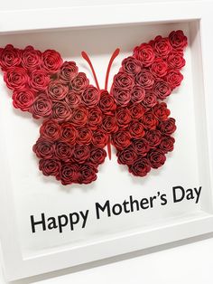 a butterfly made out of red roses in a white frame with the words happy mother's day written on it