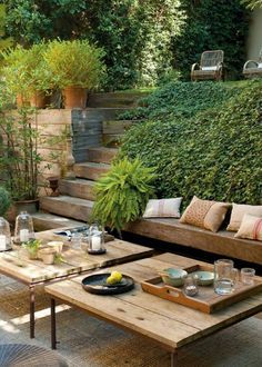 an image of a living room with couches and tables in front of some bushes