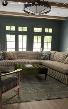 a living room filled with furniture and a large window covered in windows above the couch