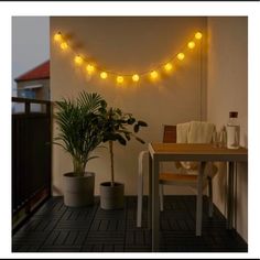 a table and chairs with lights on the wall above them in an apartment patio area