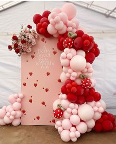 the balloon arch is decorated with flowers and hearts