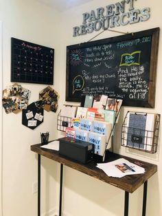 there is a blackboard with writing on it in the corner next to a table