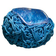 a blue bowl sitting on top of a rope