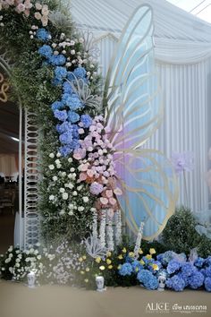 an elaborately decorated wall with flowers and a large butterfly on it's side