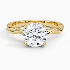 a yellow gold engagement ring with a round cut diamond in the center and twisted band