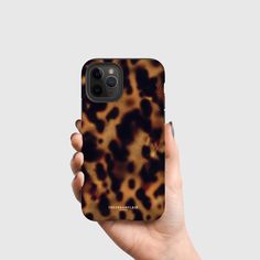 a person holding up a phone case with an animal print on it