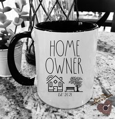 a black and white photo of a coffee mug with the words home owner on it