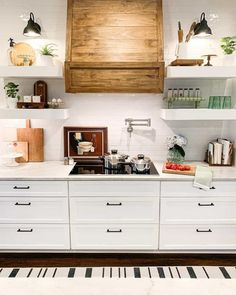 a kitchen with white cabinets and open shelves