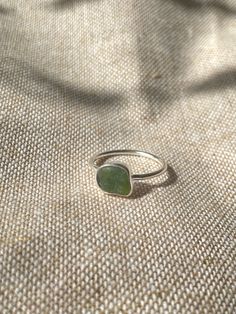 Handmade sterling silver Sea glass ring, made with recycled silver, and genuine Sea glass from the jurassic coast.  This ring has one small piece of green sea glass, and is very dainty and elegant. The ring is also stackable, especially with the other sea glass rings i have listed! This ring is a perfect gift for special occasions, and for Sea glass lovers!  The ring is size UK Q 1/2 .  All of the silver on the ring is 925 Sterling Silver, including the band! Feel free to message me for any additional information, or for commissions/custom requests! Adjustable Silver Ring With Sea Glass, Adjustable Sea Glass Ring Jewelry, Handmade Sea Glass Ring Jewelry, Handmade Adjustable Sea Glass Rings, Silver Recycled Glass Ring, Green Sterling Silver Minimalist Ring, Green Minimalist Sterling Silver Ring, Minimalist Nickel Free Sea Glass Jewelry, Minimalist Nickel-free Sea Glass Jewelry