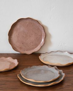 three plates sitting on top of a wooden table next to a white and brown wall