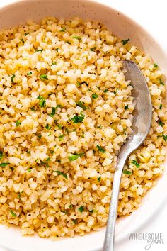 a bowl full of rice with a spoon in it