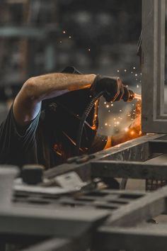 welder working on an assembly line with sparks coming from the machine and in front of him