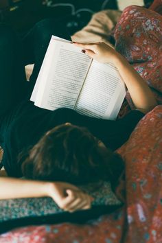 a person laying on a couch reading a book with the title doucovani