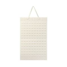 a white shopping bag hanging from the side on a wall with an adhesivee