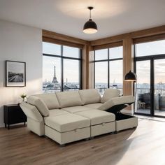 a living room filled with furniture next to large windows and a view of the eiffel tower