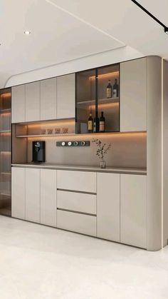 a modern kitchen with white cabinets and counter tops is shown in this image, there are bottles on the shelves