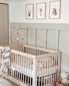 a baby's room with a crib and pictures on the wall