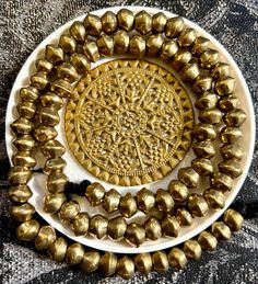 a white plate topped with lots of gold beads