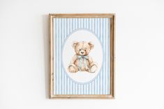 a teddy bear with a blue bow on it's head is mounted in a wooden frame