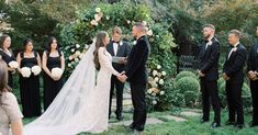 a bride and groom standing in front of their wedding party at the alter with flowers